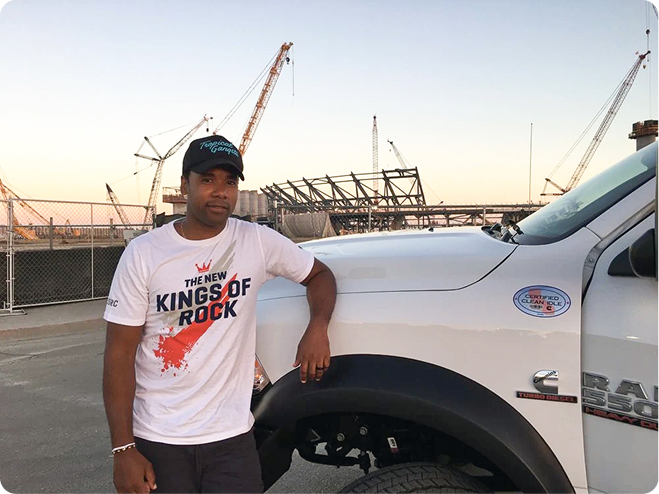 Male standing by truck with Soft Stadium in Background
